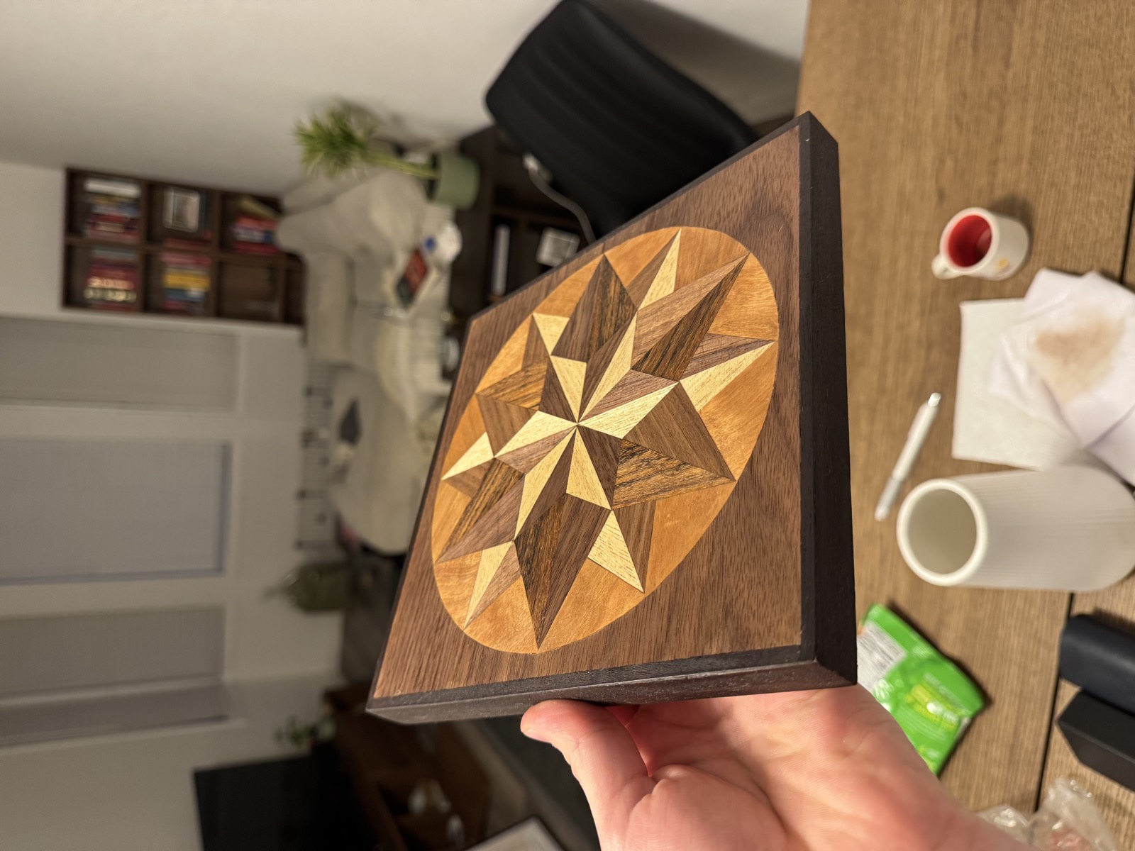 The finished compass rose seen at an angle, the grain in each piece catching the light differently