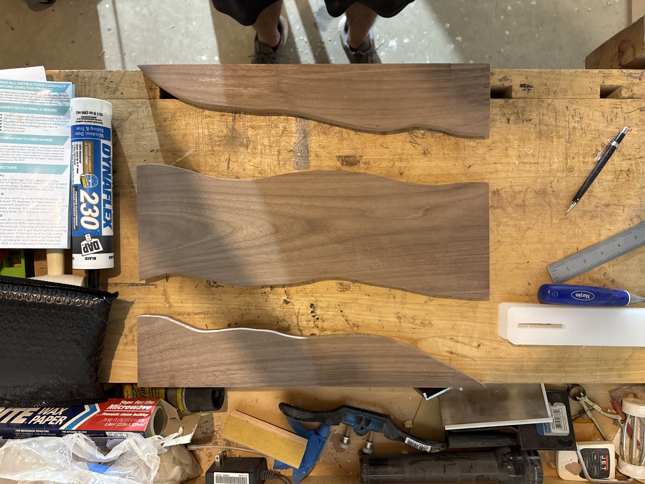 Walnut boards with a wavy edge cut into each, ready for the epoxy pour