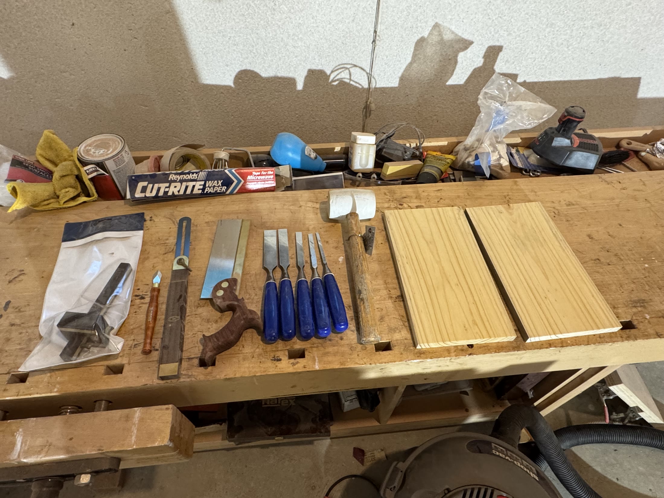 Hand tools laid out: dovetail saw, chisels, marking gauge and mallet