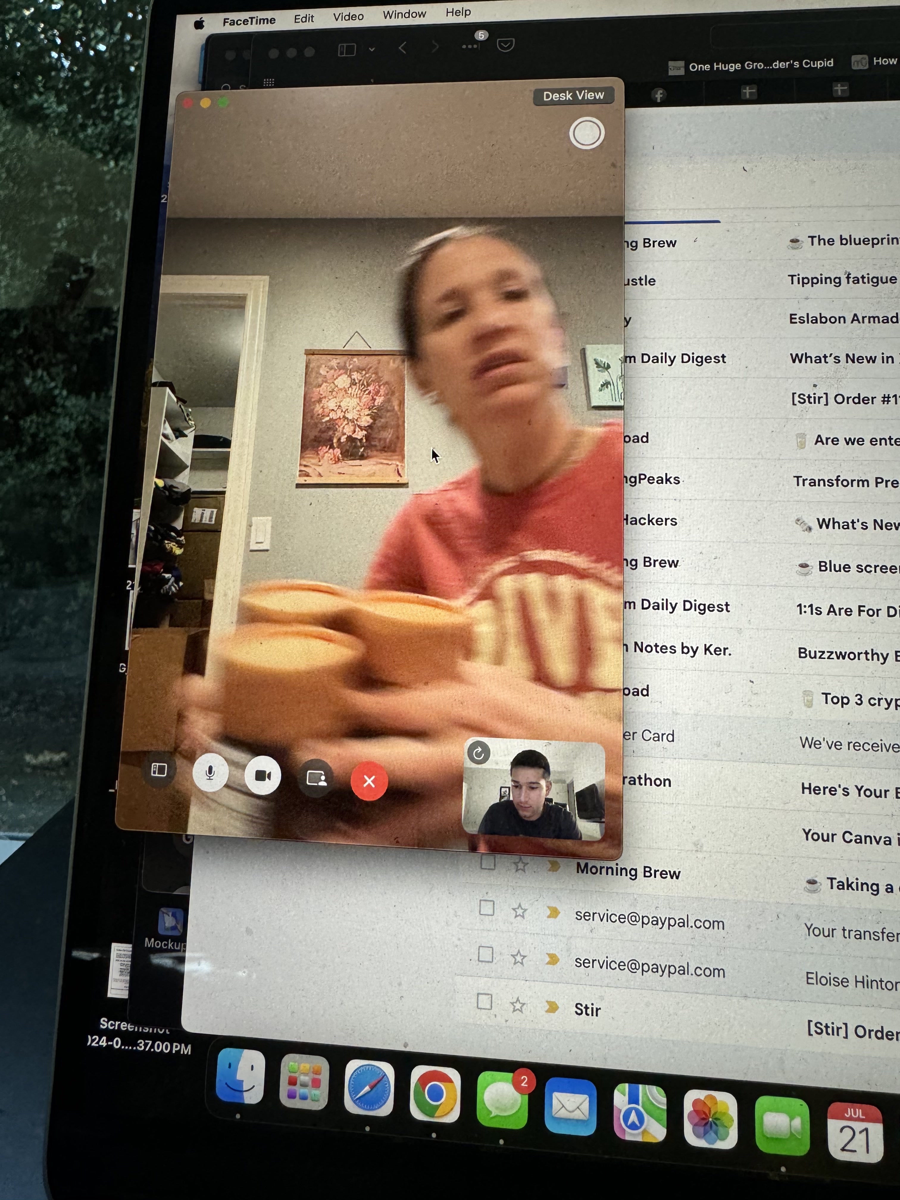 My mom on a FaceTime call holding a stack of Stir canisters while packing orders at home
